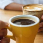 Two coffee cups about to touch